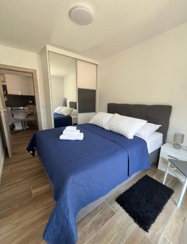 a bedroom with a blue bed with a mirror at Apartmani Antonia in Račišće