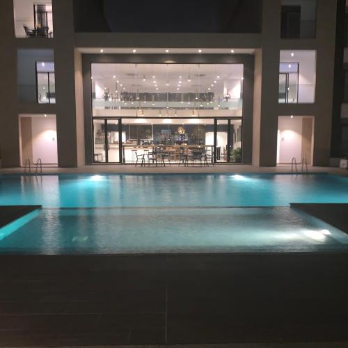 an empty swimming pool in a building at night at Accra Luxury Apartments at Embassy Gardens in Accra
