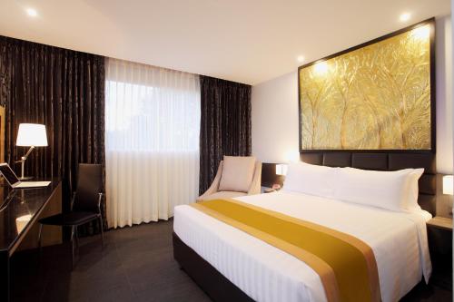 a hotel room with a large bed and a window at Nova Express Pattaya Hotel in Pattaya Central