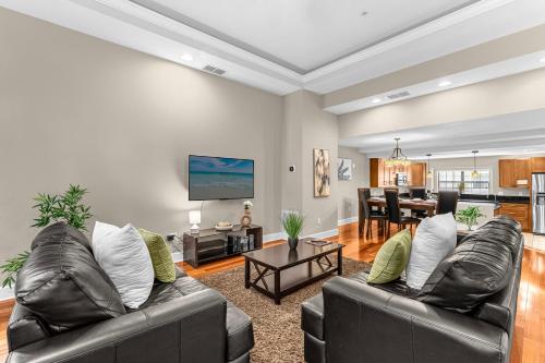 a living room with two leather couches and a table at 4BR Disney Family Townhouse Resort in Orlando - with Resort Pool, Gym, Games, & Jacuzzi in Orlando