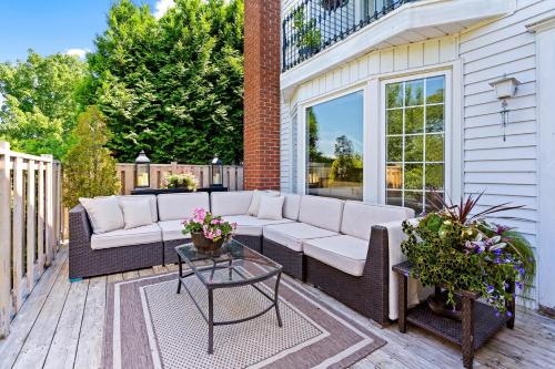 a patio with a couch and a table on a deck at Hummingbird Haven Bed & Breakfast Luxury Suite With Terrace & Seasonal Lake Views Located in Historic Old Town Niagara-On-The-Lake in Niagara-on-the-Lake