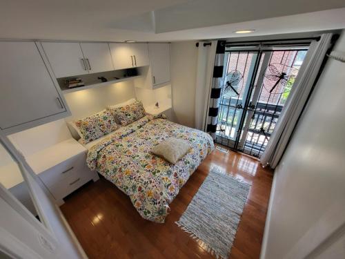 a small bedroom with a bed and a large window at Downtown Toronto House Central 2BED 2BATH Subway Free Parking in Toronto