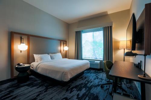 a hotel room with a bed and a window at Fairfield Inn & Suites Marquette in Marquette