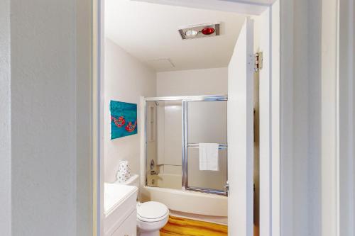 a white bathroom with a shower and a toilet at Neskowin Ocean Haven in Neskowin