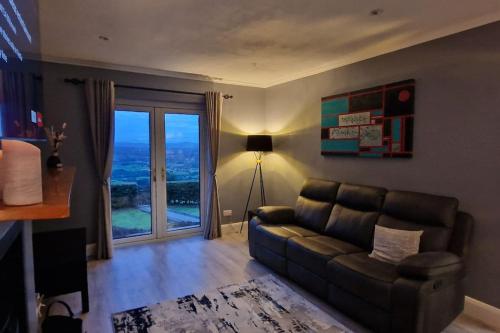 a living room with a couch and a large window at Bracken Cottage in Ballyeaston