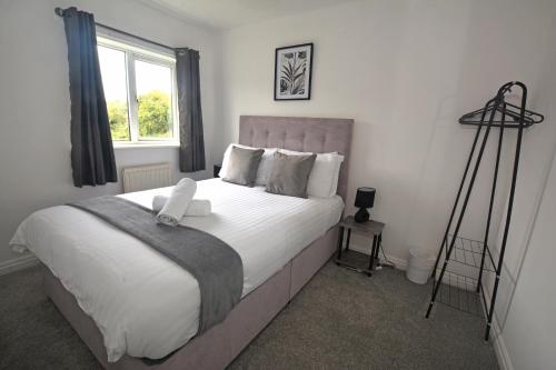 a bedroom with a large white bed with a window at Victoria Dock 3 Bedroom House sleeps 5-Free Parking-Contractor Long Stay in Hull