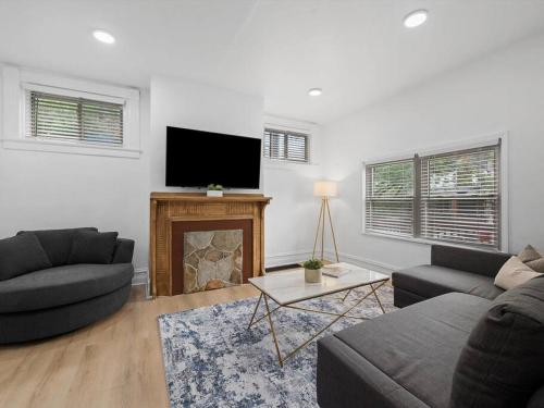 a living room with two couches and a flat screen tv at Shadyside, Central !1 Spacious & Modern 1 Bedroom with Parking in Pittsburgh