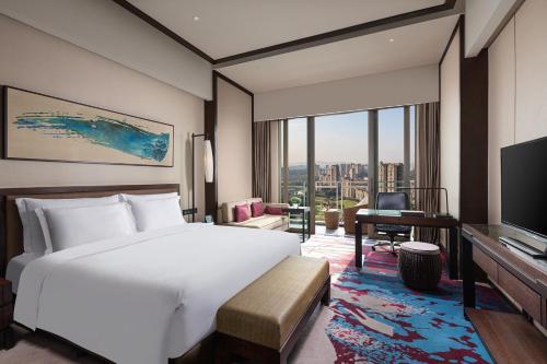 a bedroom with a bed and a desk and a television at Crowne Plaza Chongqing New North Zone by IHG in Chongqing