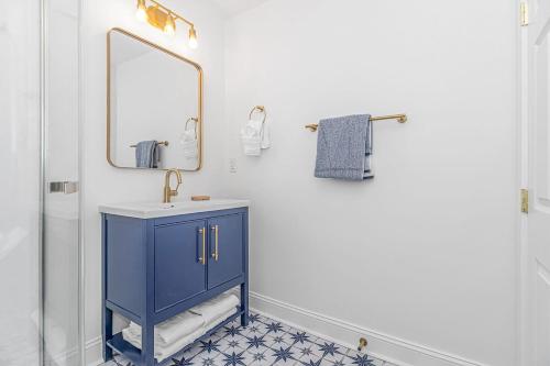 a bathroom with a blue cabinet and a mirror at Sunny Shore Retreat Near Beach in Myrtle Beach