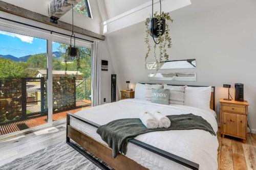a bedroom with a large bed and a balcony at A-Frame Wonders Hot Tub w Mountain Views in Colorado Springs