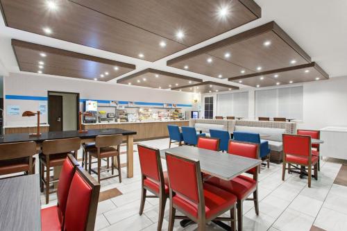 a restaurant with tables and chairs and a cafeteria at Holiday Inn Express & Suites Oakland - Airport by IHG in Oakland