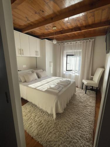 a bedroom with a large bed and a chair at Casa Mariyina in Ribadesella