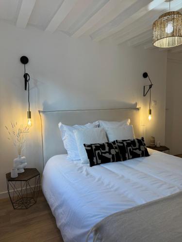 un lit avec des draps blancs et des oreillers dans une chambre dans l'établissement La Suite - Cathédrale, à Chartres