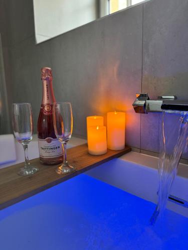 - deux verres à vin et une bouteille sur un comptoir avec des bougies dans l'établissement La Suite - Cathédrale, à Chartres