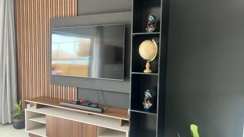 a entertainment center with a television on a wall at CasaZina in Tarrafal