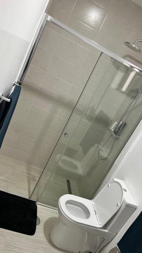 a bathroom with a toilet with a glass window at CasaZina in Tarrafal