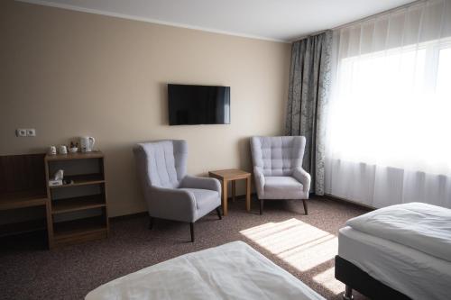 a hotel room with two chairs and a tv at Hótel Dyrhólaey in Vík