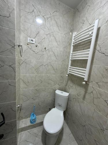 Un baño con inodoro blanco y ventana. en Gonio Tower, en Gonio