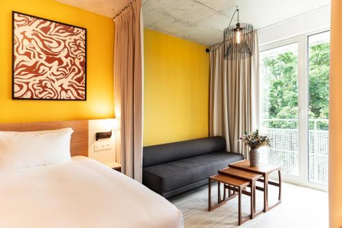 a hotel room with a bed and a couch at voco Beaune , Cité des Vins by IHG in Beaune