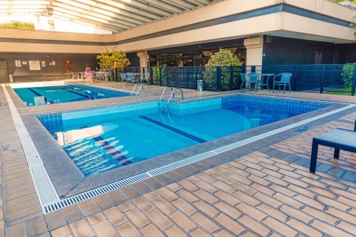 a large swimming pool with blue water at Flat Nobile Congonhas em frente ao aeroporto - H614 in São Paulo