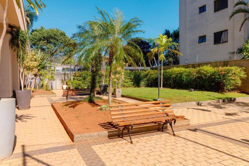 a group of benches in a park with palm trees at Flat Nobile Congonhas em frente ao aeroporto - H614 in São Paulo
