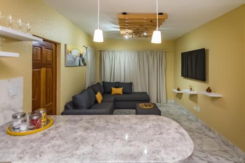 a living room with a blue couch and a tv at Azies - The Willows in Johannesburg
