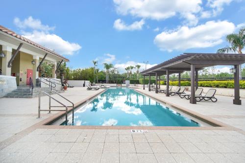 a swimming pool with benches and a pavilion at 4BR Disney Family Townhouse Resort in Orlando - with Resort Pool, Gym, Games, & Jacuzzi in Orlando