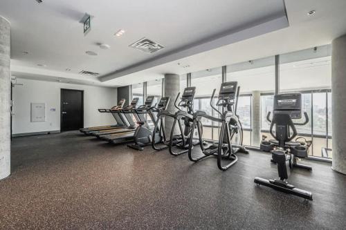 a gym with a row of exercise bikes and treadmills at Union Towers Condo with City Views and Patio in Kitchener