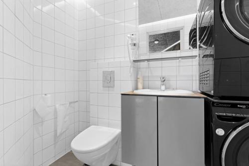 a white bathroom with a toilet and a sink at Fun Art Holiday Apartment Lots Of Fun For The Whole Family! in Pandrup