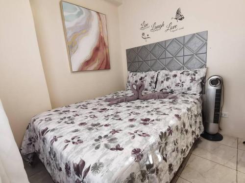 a bedroom with a bed with a floral bedspread at 2BR Charming Condo near Session road and Sm Goshenland Towers in Baguio