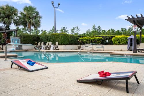 a swimming pool with two flip flops and a water slide at 4BR Disney Family Townhouse Resort in Orlando - with Resort Pool, Gym, Games, & Jacuzzi in Orlando