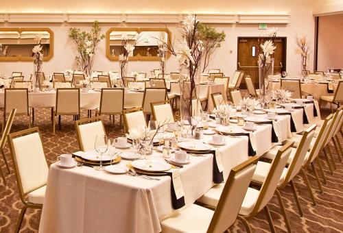 a banquet hall with white tables and chairs at Ashland Hills Hotel & Suites in Ashland