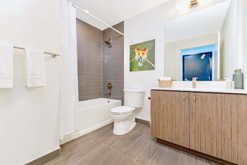 a bathroom with a toilet and a tub and a sink at Union Towers Condo with City Views and Patio in Kitchener