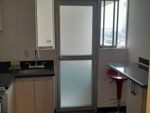 a kitchen with a sliding glass door in a kitchen at Depa El Polo, Embajada USA, Surco in Lima