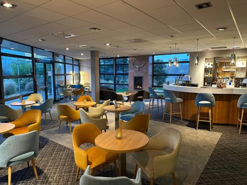 a restaurant with tables and chairs and a bar at Holiday Inn - Strasbourg - Nord by IHG in Schiltigheim