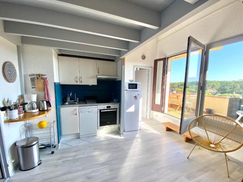 une cuisine avec des appareils blancs et une grande fenêtre dans l'établissement Appartement lumineux à 4 min de la plage avec terrasse, parking privé et WIFI ! - FR-1-239-999, à Seignosse