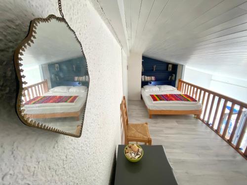 - 2 lits dans une chambre avec un miroir mural dans l'établissement Appartement lumineux à 4 min de la plage avec terrasse, parking privé et WIFI ! - FR-1-239-999, à Seignosse