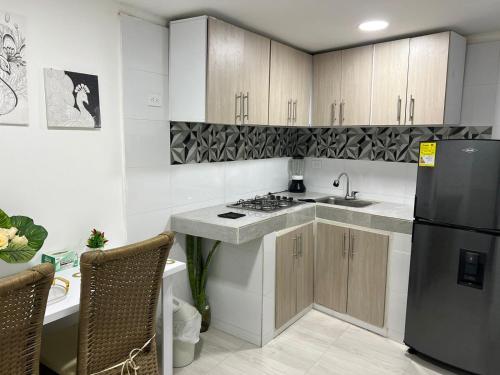 a kitchen with a sink and a refrigerator at Habitaciones villa oti in Ciénaga