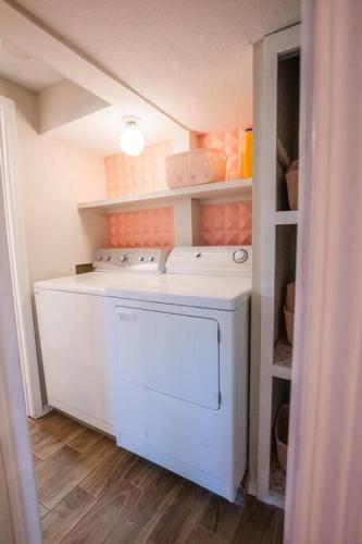 a laundry room with a white washer in a room at 50 Shades of Pink-Private Hot Tub! in Albuquerque