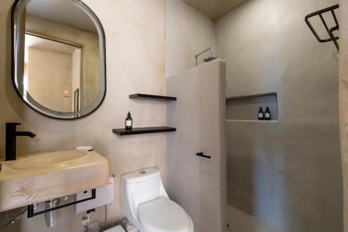 a bathroom with a sink and a toilet and a mirror at Casa Arkana Zicatela by Grupo Amber in Brisas de Zicatela