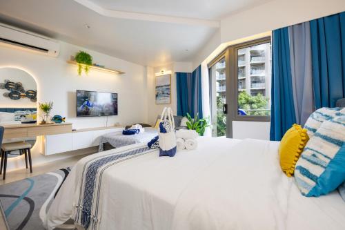 a bedroom with a large white bed and a desk at Cerulean Bliss Condo at Tambuli Mactan Fast Wifi Netflix in Lapu Lapu City