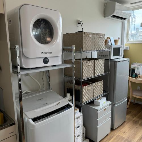 a laundry room with a washing machine on a shelf at Stay&Work HIRAJO in Yokote