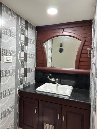 a bathroom with a sink and a mirror at Backwater Bay in Edappally