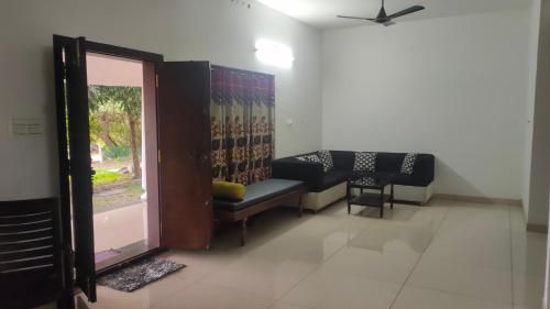 a waiting room with a couch and a window at Backwater Bay in Edappally