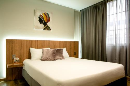 a bedroom with a large bed and a window at Aerosuites in Bogotá