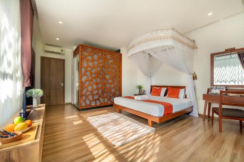 a bedroom with a bed with orange pillows and a piano at U Maison by Class6 in Hoi An