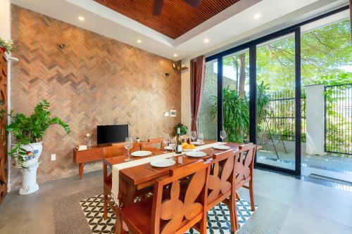 a dining room with a large wooden table with chairs at U Maison by Class6 in Hoi An