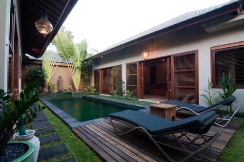 a backyard with a swimming pool and a house at Ajanta Villa in Sanur
