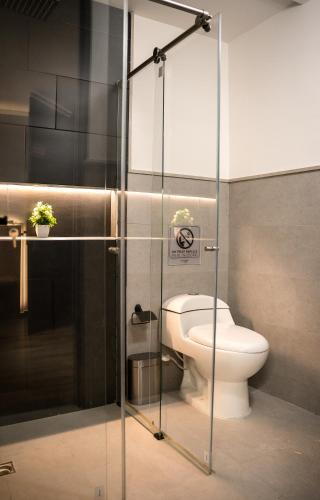 a bathroom with a toilet and a glass shower stall at Aerosuites & SkyHub in Bogotá