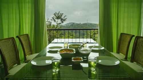 a table with food and drinks on a balcony at Homestay Namaha in Meppādi